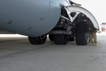 Maj. Benjamin Buxton, 16th Airlift Squadron pilot, inspects the tires of a C-17 Globemaster III aircraft headed to Argentina before take off at Joint Base Charleston, Nov. 18, 2017. Joint Base Charleston's efforts are helping aid the search and rescue of the A.R.A. San Juan, an Argentine navy submarine that went missing Nov. 15, 2017. As part of the support, two C-17 Globemaster IIIs and one C-5M Super Galaxy from Air Mobility Command are delivering needed equipment and expertise to assist a partner nation. The first flight from Joint Base Charleston is carrying a tow bar, a Tunner 60K Aircraft Cargo Loader and three members of the 437th Aerial Port Squadron. While on the ground, the team will be conducting runway assessments prior to other equipment arriving in country. Additional U.S. Air Force support will be provided to aid efforts.