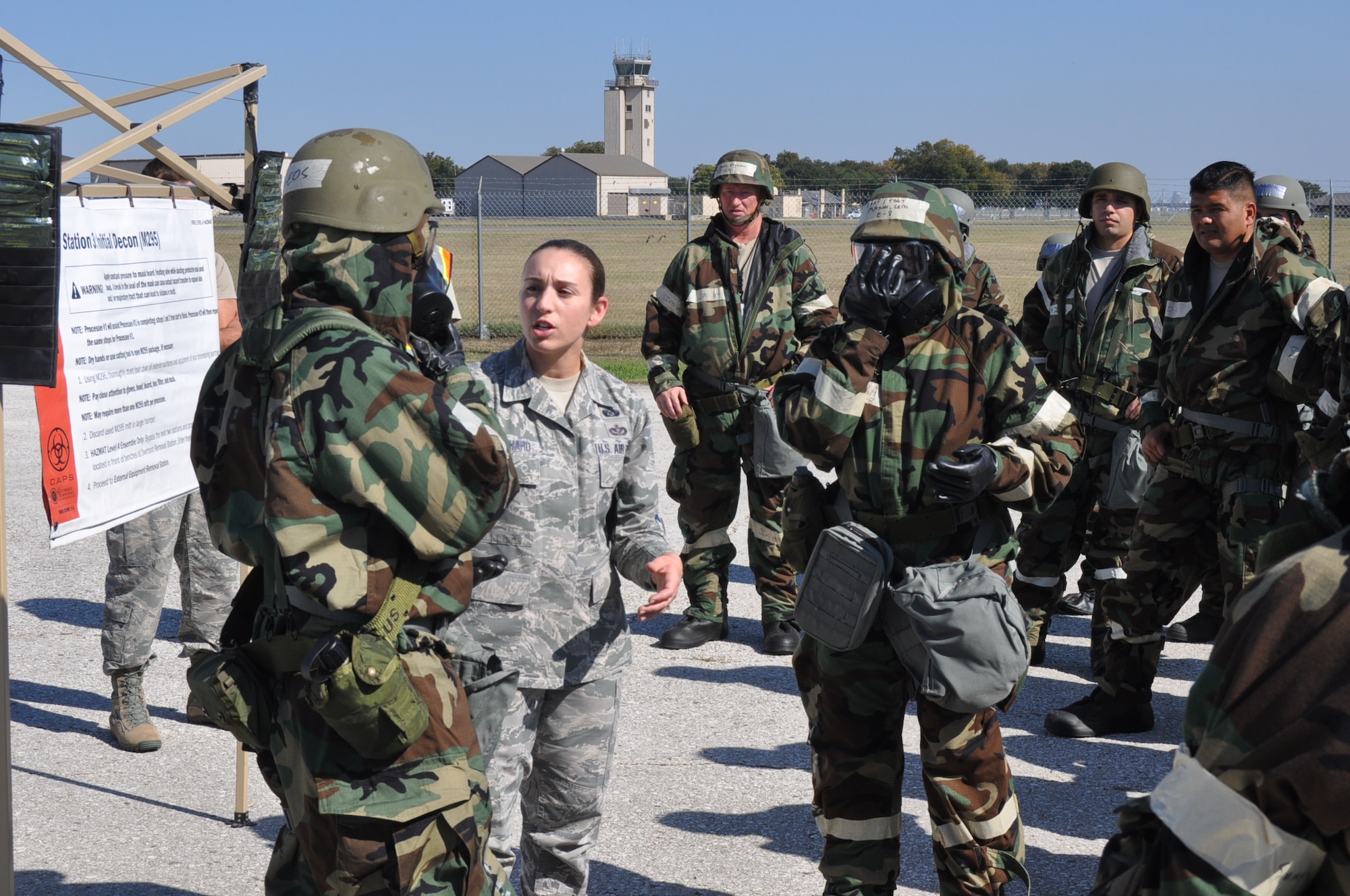 (Center) Senior Master Sgt. Leia Bernhard, 733rd Training Squadron first sergeant, provides guidance and training on how to properly go through the decontamination zone during an Ability to Survive and Operate training exercise on Joint Base San Antonio-Lackland, Texas on Nov. 18, 2017. Both ground Reserve Citizen Airmen and air crew members participated in the exercise and were required to go through a decontamination zone to prevent the spread of any potential chemicals spreading. (U.S. Air Force photo/Senior Airman Bryan Swink)