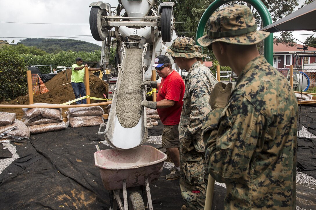 U.S. Marines help local community volunteers fill wheelbarrows with cement during a construction project. The Marines are with Combat Logistics Battalion 3, and are helping rebuild a community playground at Kamuela, on the island of Hawaii, Oct. 28, 2017. (U.S. Marine Corps photo by Lance Cpl. Isabelo Tabanguil)