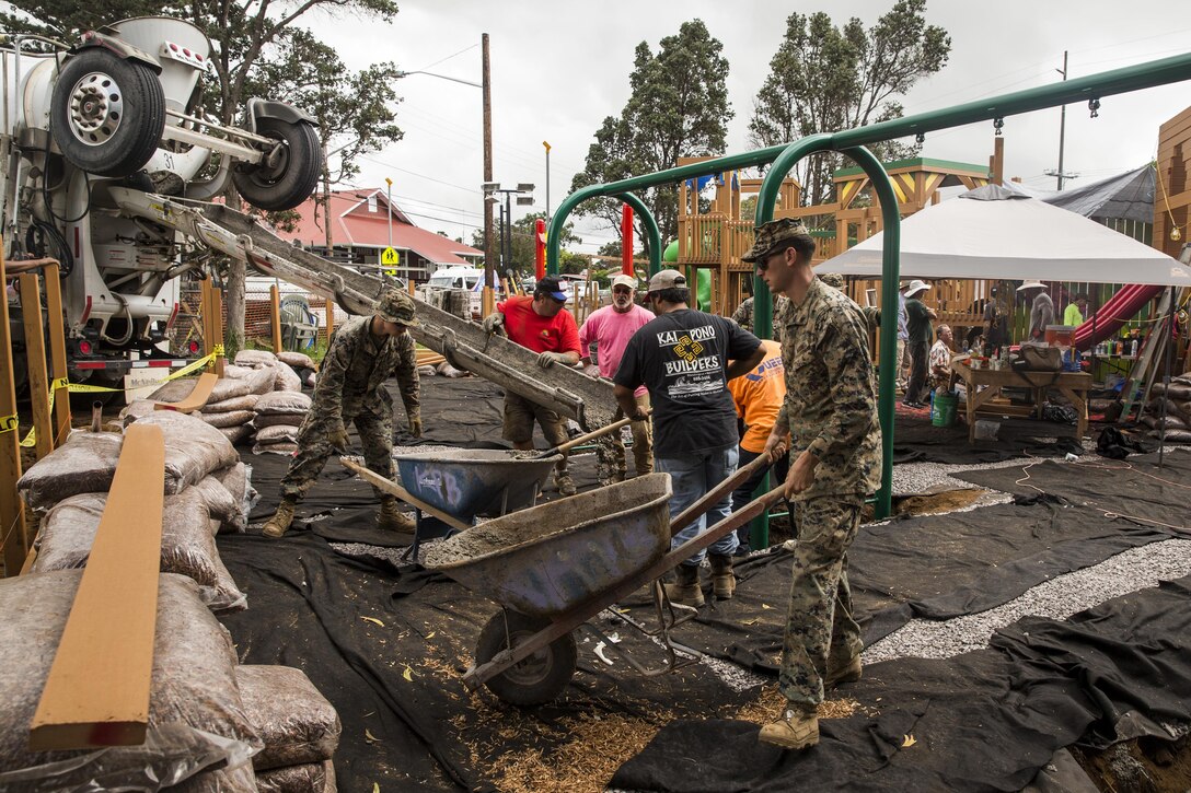 U.S. Marines dump and refill wheelbarrows full of cement during a construction project. The Marines are with Combat Logistics Battalion 3, and are helping rebuild a community playground at Kamuela, on the island of Hawaii, Oct. 28, 2017. (U.S. Marine Corps photo by Lance Cpl. Isabelo Tabanguil)
