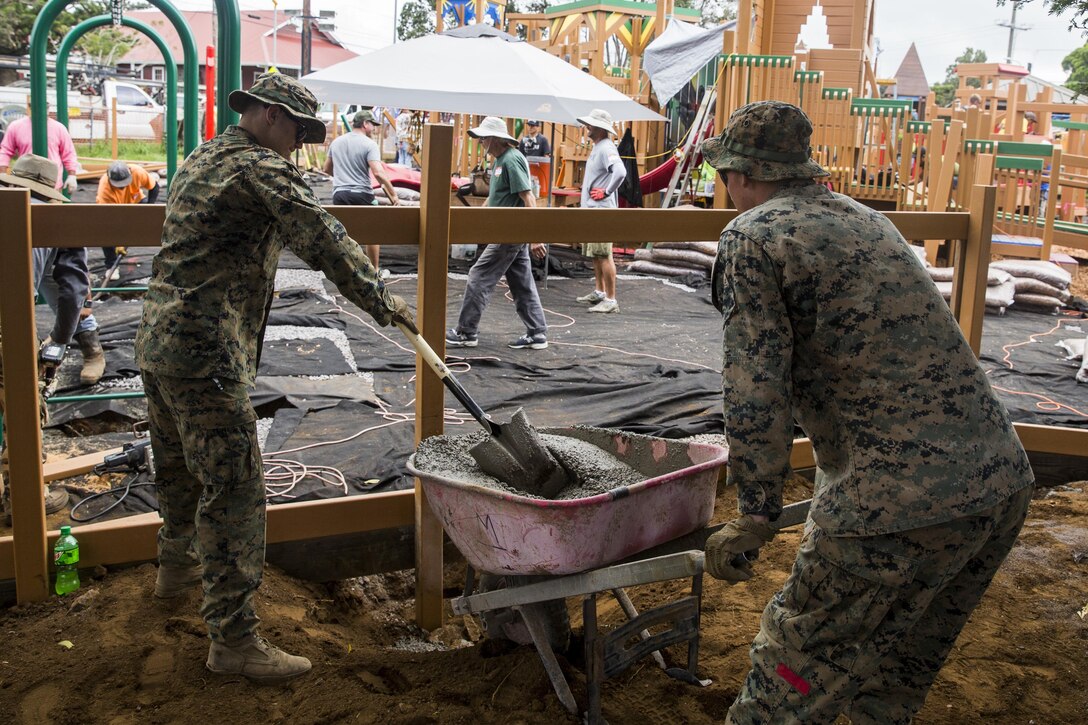 U.S. Marines place cement at the bottom of a fencepost during a construction project. The Marines are with Combat Logistics Battalion 3, and are helping rebuild a community playground at Kamuela, on the island of Hawaii, Oct. 28, 2017. (U.S. Marine Corps photo by Lance Cpl. Isabelo Tabanguil)
