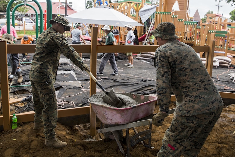 U.S. Marines place cement at the bottom of a fencepost during a construction project. The Marines are with Combat Logistics Battalion 3, and are helping rebuild a community playground at Kamuela, on the island of Hawaii, Oct. 28, 2017. (U.S. Marine Corps photo by Lance Cpl. Isabelo Tabanguil)