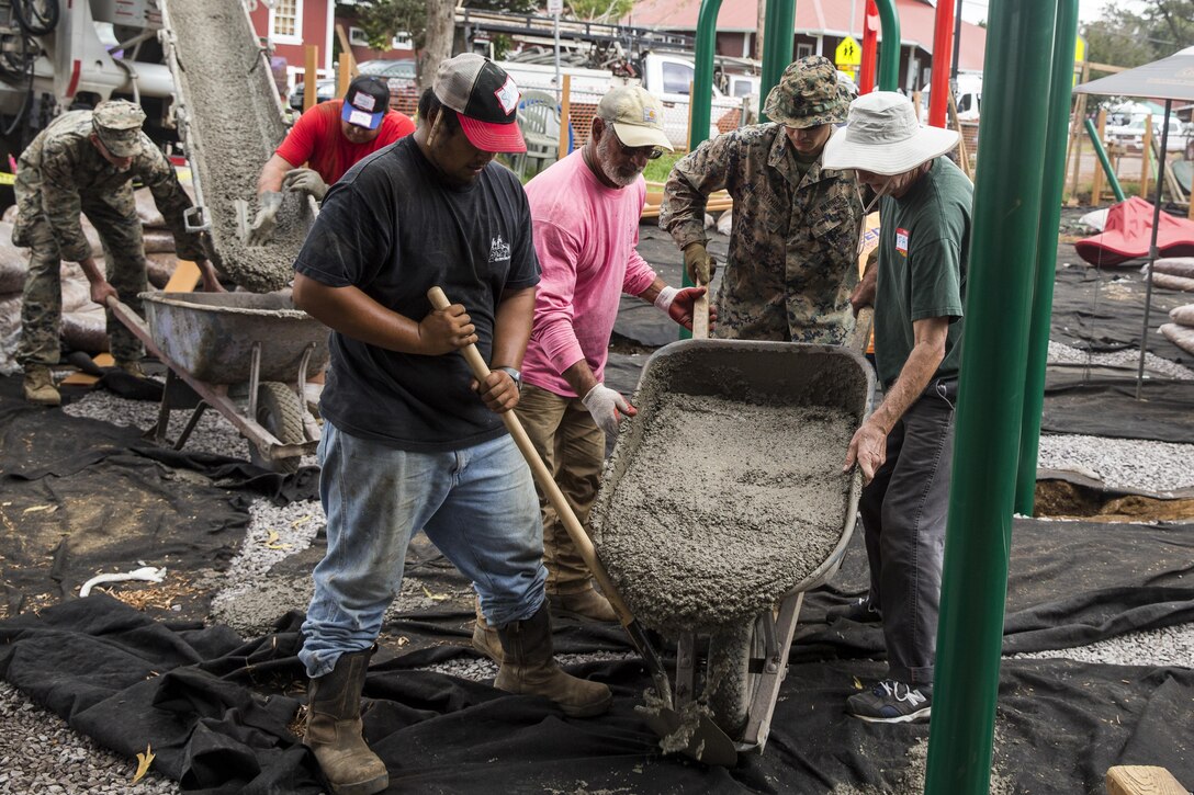 Pfc. Jonathan Seymour pours cement into the foundation of a swing set alongside local community volunteers during a construction project at Kamuela, on the island of Hawaii, Oct. 28, 2017. Seymour is a landing support specialist with Combat Logistics Battalion 3, and a native of New Market, Md. U.S. Marines with CLB-3 are helping rebuild a local community playground alongside volunteers from Kamuela. (U.S. Marine Corps photo by Lance Cpl. Isabelo Tabanguil)