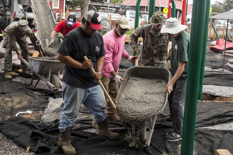 Pfc. Jonathan Seymour pours cement into the foundation of a swing set alongside local community volunteers during a construction project at Kamuela, on the island of Hawaii, Oct. 28, 2017. Seymour is a landing support specialist with Combat Logistics Battalion 3, and a native of New Market, Md. U.S. Marines with CLB-3 are helping rebuild a local community playground alongside volunteers from Kamuela. (U.S. Marine Corps photo by Lance Cpl. Isabelo Tabanguil)
