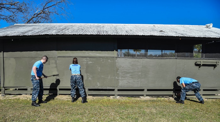 Joint Base Charleston members paint a Vietnam Memorial exhibit during the Day of Caring volunteer event at Patriot’s Point, Mount Pleasant, S.C., Nov. 17, 2017.