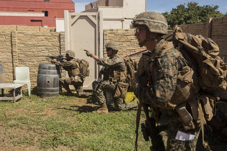 Lance Cpl. Travis Catero points out a building at a Military Operations in Urban Terrain town during a Tactical Recovery of Aircraft and Personnel training event in Exercise Bougainville II at Landing Zone Boondocker, Marine Corps Base Hawaii, on Oct. 26, 2017. Lance Cpl. Catero is a mortarman with 2nd Battalion, 3rd Marine Regiment, and a native of Phoenix, Ariz. Exercise Bougainville II prepares 2nd Bn., 3rd Marines for service as a forward deployed force in the Pacific by training them to fight as a ground combat element in a Marine Air-Ground Task Force. (U.S. Marine Corps photo by Lance Cpl. Isabelo Tabanguil)