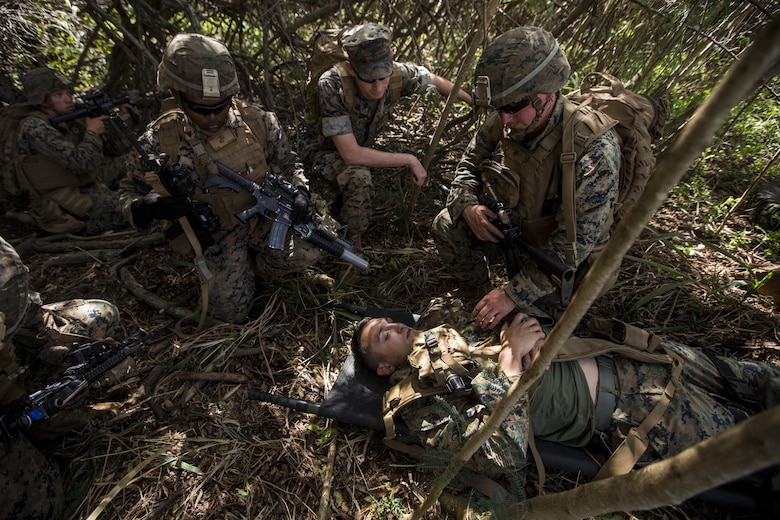 Cpl. Nathan Blue (left), Hospitalman Second Class Jonathan Alexander (middle), and Hospitalman Third Class Timothy Lucsom (right), oversee 2nd Lt. Mark Mabry playing a simulated downed pilot during a Tactical Recovery of Aircraft and Personnel training event in Exercise Bougainville II at Landing Zone Boondocker, Marine Corps Base Hawaii, on Oct. 26, 2017. Cpl. Blue is a mortarman, and a native of El Paso, Texas. HM2 Alexander and HM3 Lucsom are corpsmen. HM2 Alexander is a native of Colorado Springs, Colo., and HM3 Lucsom is a native of Buffalo, N.Y. 2nd Lt. Mabry is an infantry officer, and is a native of Benson, Ariz. All Marines and Sailors are with 2nd Battalion, 3rd Marine Regiment. Exercise Bougainville II prepares 2nd Bn., 3rd Marines for service as a forward deployed force in the Pacific by training them to fight as a ground combat element in a Marine Air-Ground Task Force. (U.S. Marine Corps photo by Lance Cpl. Isabelo Tabanguil)