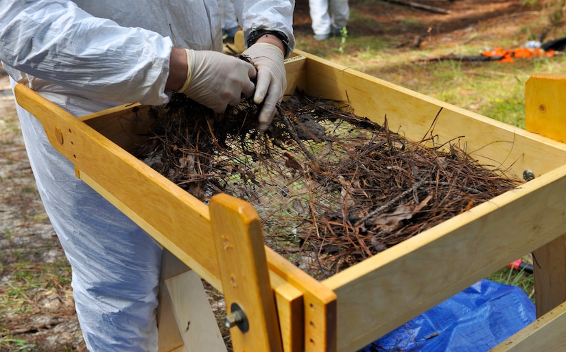 A participant sifts through dirt to recover potential ‘evidence’ during a clandestine grave and human remains recovery training at Joint Base Charleston, S.C., Nov. 14, 2017.