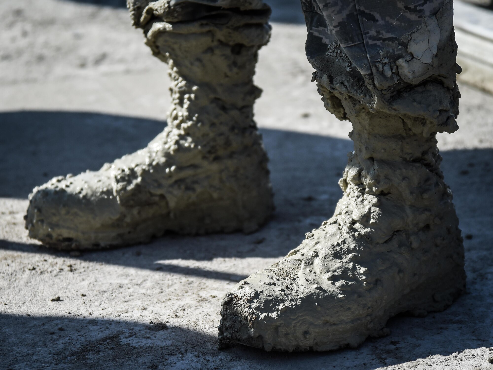 Concrete begins to cure on the boots of U.S. Air Force Airman 1st Class Ryan Williams, 773d Civil Engineer Squadron, after a Rapid Airfield Damage Repair training exercise at Gwangju Air Base, Republic of Korea., Nov. 9, 2017. U.S. and R.O.K. Airmen trained together for a week to learn the new RADR process, preparing them for response to wartime contingencies, enhancing interoperability and building partnership capacity in the Indo-Asia Pacific region. The civil engineers teamed up to complete an airfield damage repair exercise on a mock airstrip with multiple craters, testing the team's ability to restore a runway to operational status as quickly as possible. (U.S. Air Force photo by Senior Airman Curt Beach)