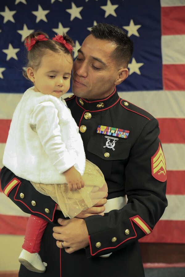 Marine Corps veteran Sgt. Eubaldo Lovato, a Silver Star recipient, holds his daughter prior to his Silver Star award ceremony in Montrose, Colo., Nov. 18, 2017. Lovato received an award upgrade, from his previous Bronze Star, for his heroic actions while serving as a squad leader with Company A, 1st Battalion, 8th Marine Regiment, 1st Marine Division, during Operation Al Fajr, part of Operation Iraqi Freedom, on Nov. 15, 2004. The Silver Star is the United States third-highest personal decoration for valor in combat. (U.S. Marine Corps photo by Pfc. Samantha Schwoch/Released)