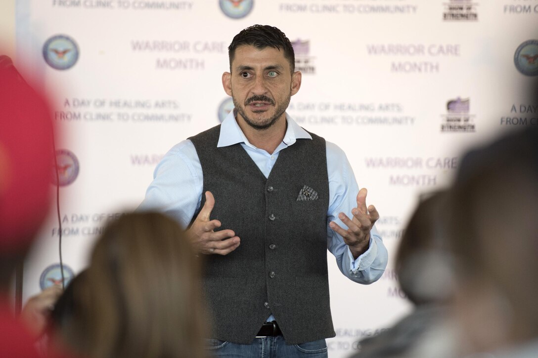 A man stands and speaks to an audience.