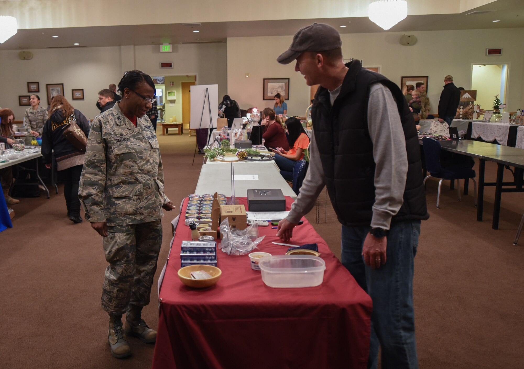 Robert Justice, a vender at the health fair, shows shaving products to Col. Cherron Galluzzo, 90th Medical Group commander, during the Warren top 3 craft fair and health fair on F.E. Warren Air Force Base Wyo, Nov. 17, 2017. Justice, crafts and packages each bar of shaving soap he sells by hand. (U.S. Air Force photo by Airman 1st Braydon Williams)