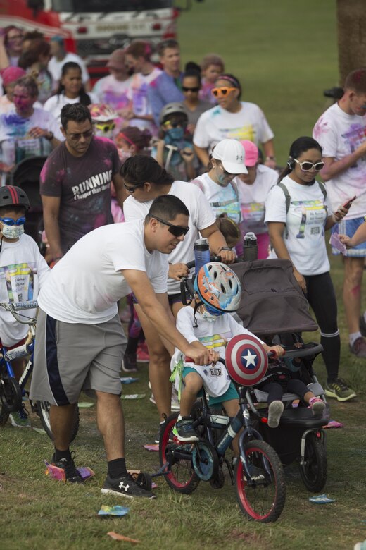 TORII STATION, OKINAWA, Japan – A father guides his son during the 5th Annual USO Okinawa Color Blast 5K Fun Run Nov. 18 on Torii Station Beach, Okinawa, Japan.