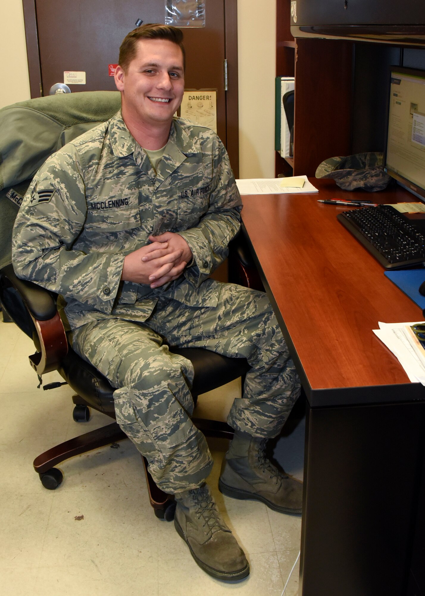 Senior Airman Michael McClenning poses for a photo at his desk Nov. 20, 2017 at Warfield Air National Guard Base, Middle River, Md. McClening spends his days off riding dirt bikes with his friends preparing for the next motocross race they will enter. (U.S. Air National Guard photo by Senior Airman Enjoli Saunders)