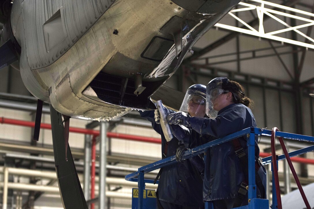 U.S. Air Force Senior Airman Rachel Revels (left), and U.S. Air Force Staff Sgt. Lindsay Hallford, both C-130J Super Hercules crew chiefs, scrub the grime off of a C-130J engine on Ramstein Air Base, Germany, Nov. 20, 2017. Airmen scrub the exterior of the aircraft with a cleaning solution repeatedly, then spray it with hot water to ensure it is clean. (U.S. Air Force photo by Airman 1st Class Devin M. Rumbaugh)