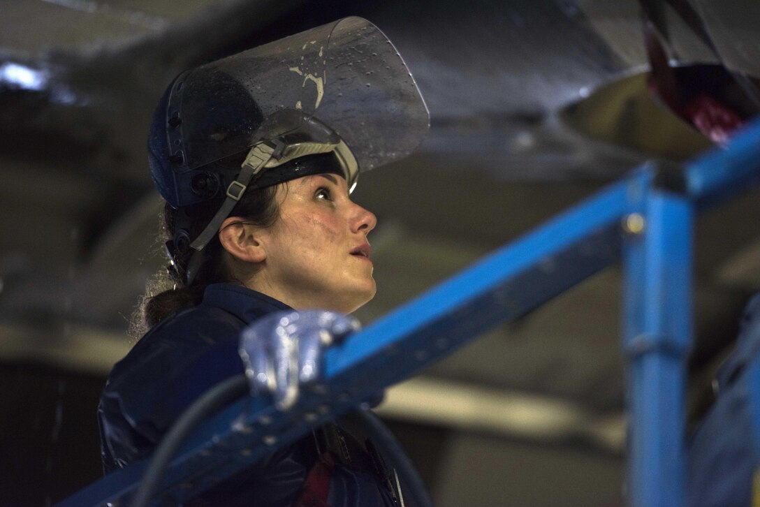 U.S. Air Force Staff Sgt. Lindsay Hallford, 86th Maintenance Squadron C-130J Super Hercules crew chief, takes a break while looking at the engine of a C-130J on Ramstein Air Base, Germany, Nov. 20, 2017. Crew chiefs clean the aircraft with a special cleaning solution and hot water. (U.S. Air Force photo by Airman 1st Class Devin M. Rumbaugh)