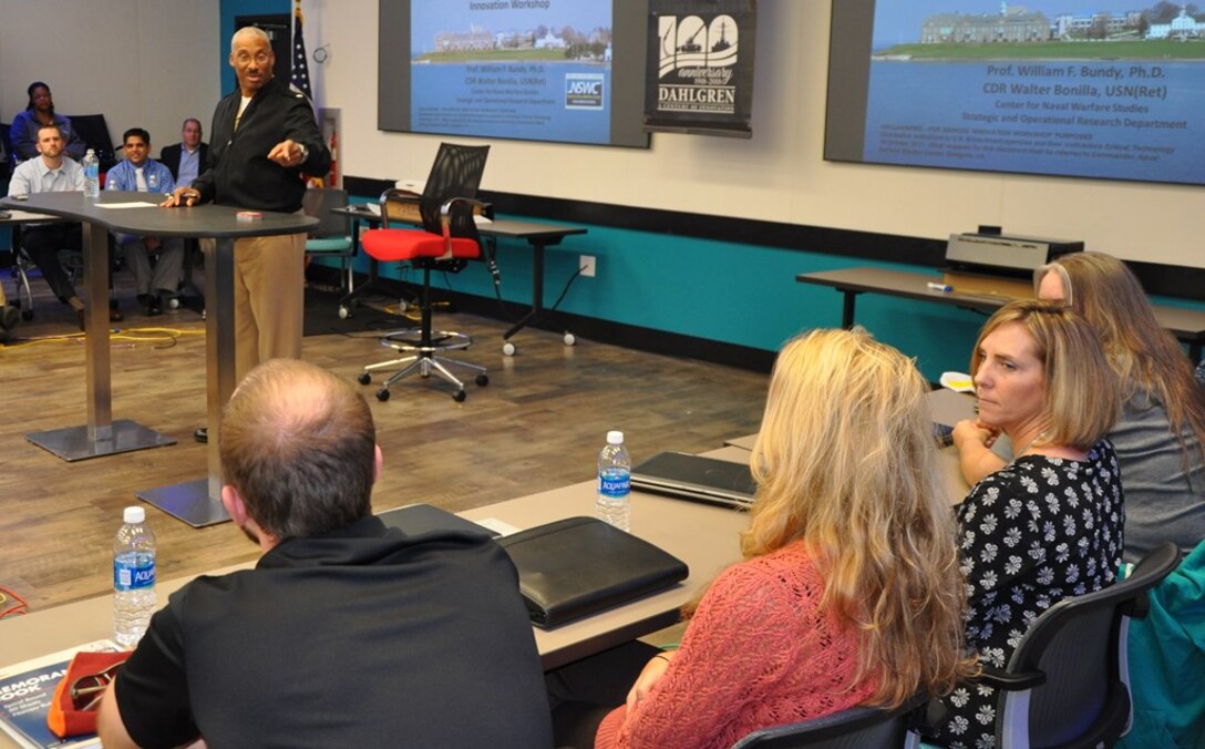 IMAGE: DAHLGREN, Va. - Rear Adm. Jesse Wilson, Naval Surface Force Atlantic commander, emphasizes the importance of innovating to the strategic environment as he spoke to a group of civilian technologists and military officers at the first in a series of Surface Warfare Innovation Workshops held at the Navy's newest Innovation Lab. Naval Surface Warfare Center Dahlgren Division (NSWCDD) and the Navy War College co-sponsored the event that encouraged NSWCDD scientists and engineers to throw away the rule book as they brainstormed to solve future warfighting scenarios. "The workshop enabled Navy leadership to share current and future Fleet concerns with our new and mid-career personnel to develop united, focused, and creative solutions," said NSWCDD I-Lab Director of Innovation Nelson Mills.