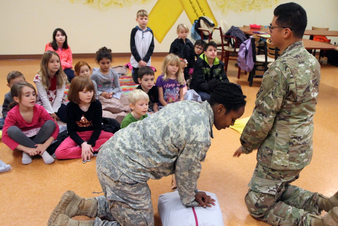 Two Army medics teach home-schoolers CPR techniques.