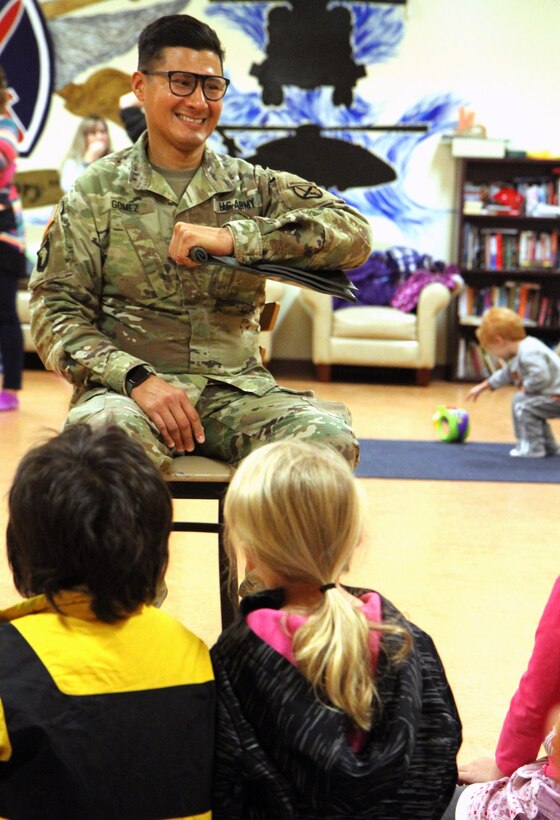 A soldier demonstrates first aid techniques to children.