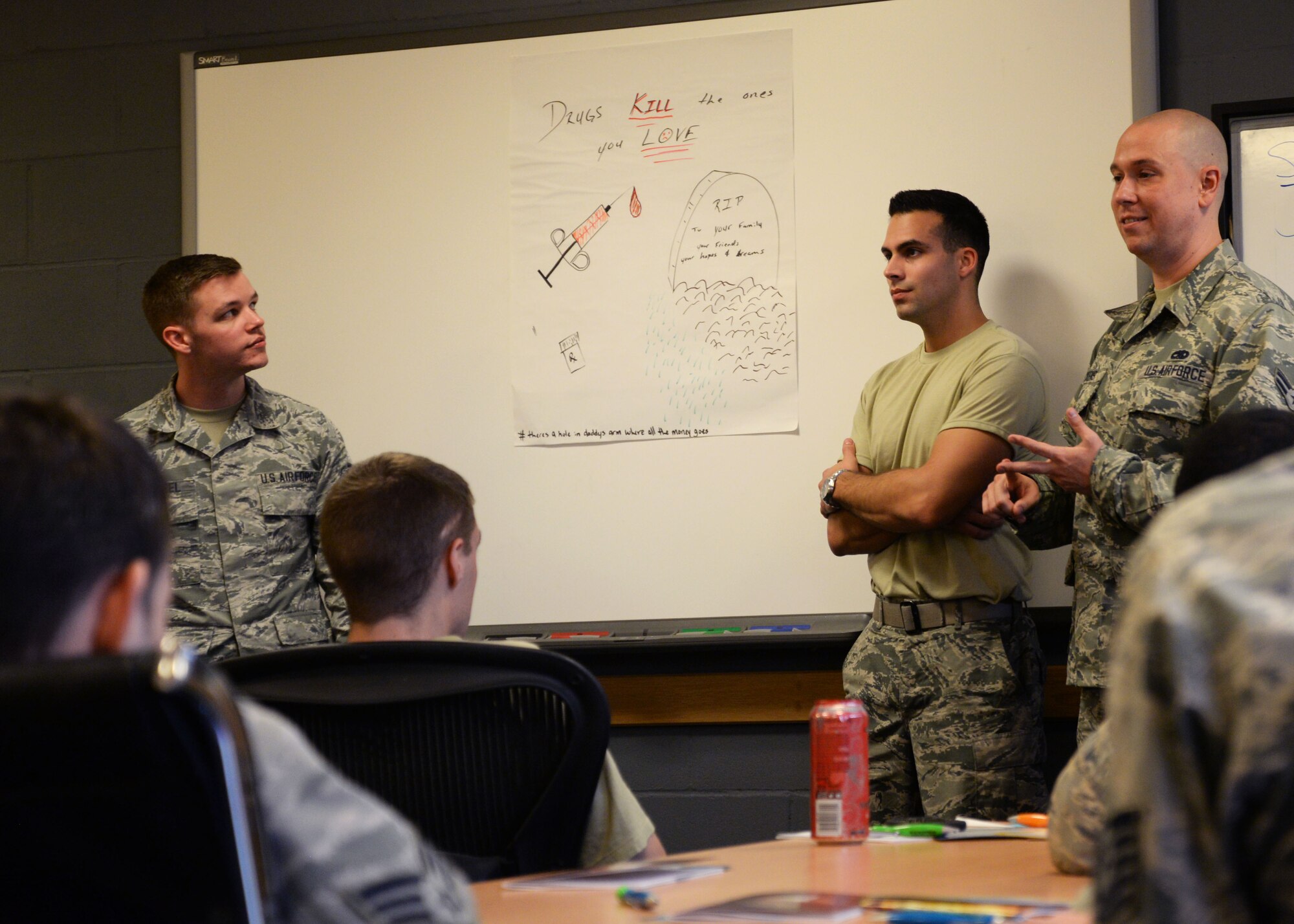 U.S Air Force Senior Airman Jeremy Whetzel, Staff Sgt. Branden Newman and Staff Sgt. Travis Weaver present an anti-drug campaign during the Four Lenses training at RAF Mildenhall, England, Oct. 24, 2017. The campaign is meant to be advertised to their opposite personality to learn how to communicate better. The Equal Opportunity office offers a variety of conflict resolution training and mediation, focusing on team building and understanding. (U.S. Air Force photo by Airman 1st Class Alexandria Lee)