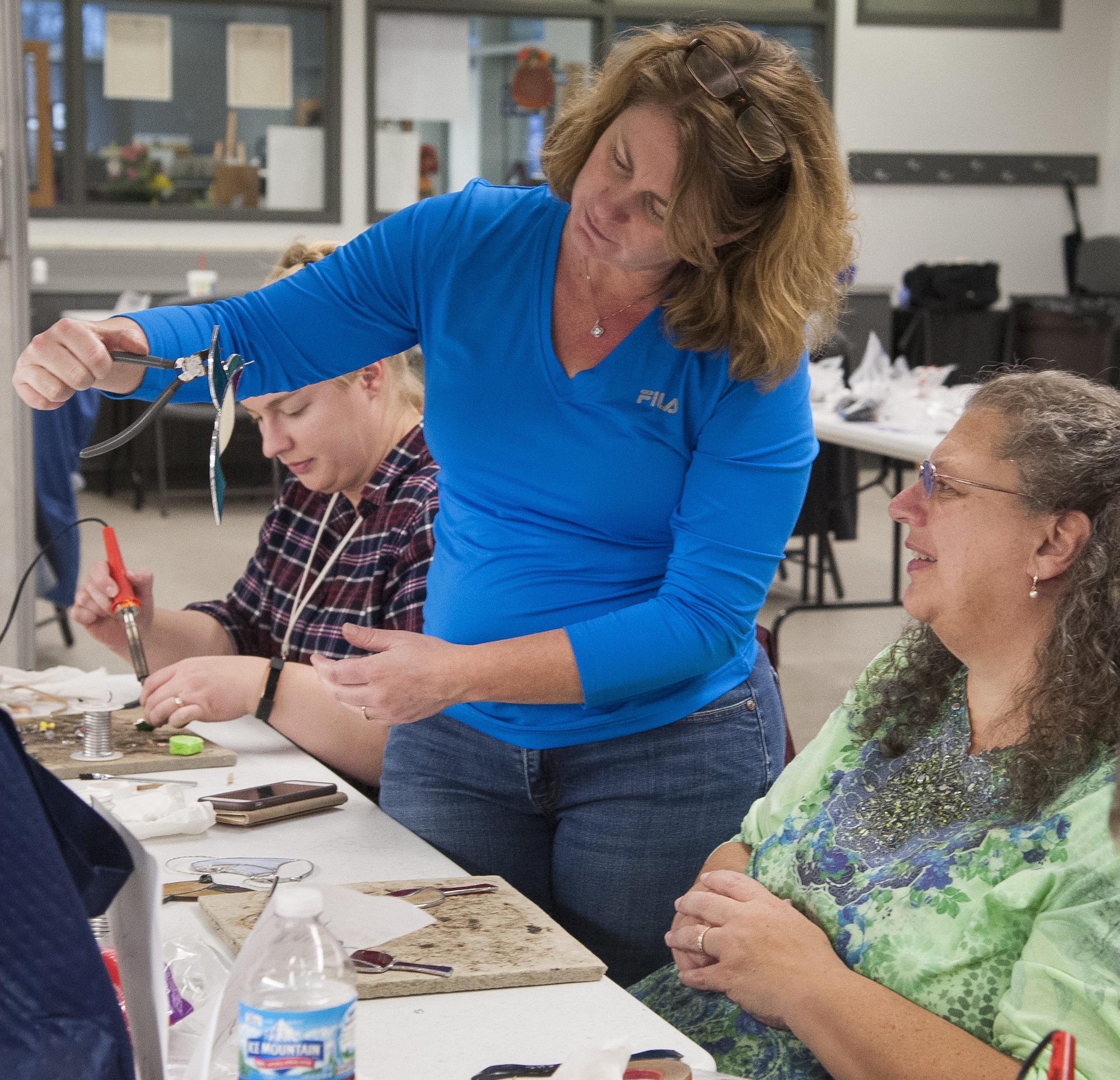 Instructor Jamie Morley offers advise on the next step for participant Theresa Rittenhouser's project during a holiday themed stained glass workshop at the Consolidated Hobby Complex on Wright-Patterson Air Force Base, Ohio, Nov.18, 2017. Morley has been teaching stained glass art form classes at the complex for 15 years. Rittenhouser took the workshop with her husband Tom, her son Christopher, and her daughter-in-law Laura. (U.S. Air Force photo/Jim Varhegyi)