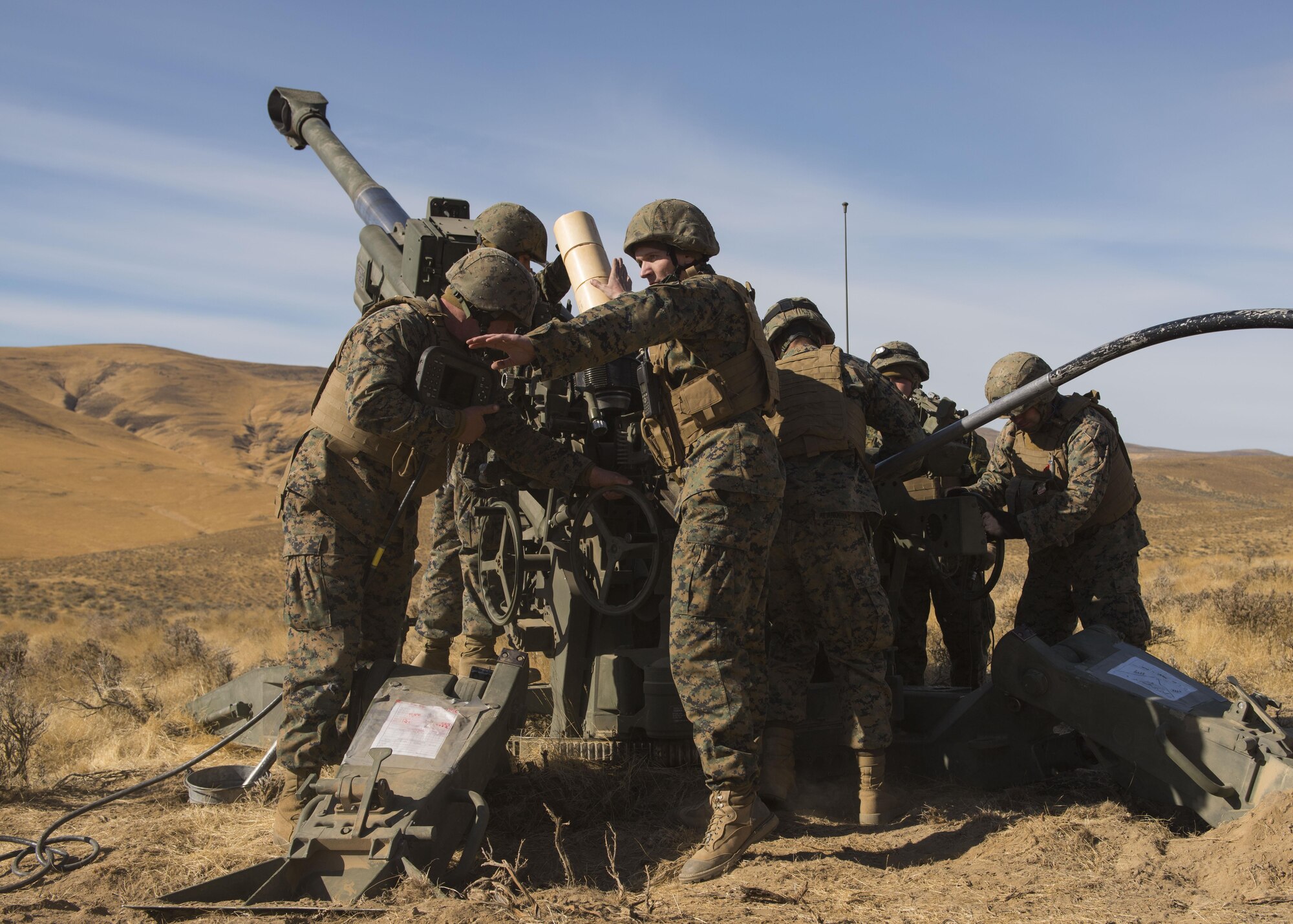 Staff Sgt. Alexx Bullion, Reserve Marine P Battery 5/14 artillery section chief, calls out orders to Marines manning a M777A2 howitzer weapon system during a live-fire training exercise at the Yakima Training Center, Washington, Oct 14, 2017. USMC Battery P conducts four live-fire artillery exercises performed each year, in addition to small-arms marksmanship and machine gun training. (U.S. Air Force photo/Senior Airman Ryan Lackey)