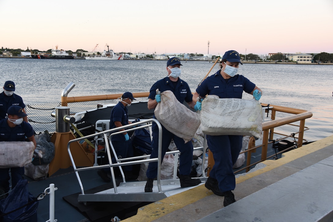 Crewmembers from the Coast Guard Cutter Pelican offload approximately one ton of cocaine