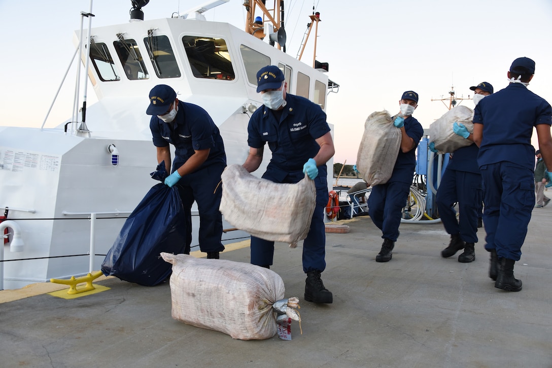 Crewmembers from the Coast Guard Cutter Pelican offload approximately one ton of cocaine