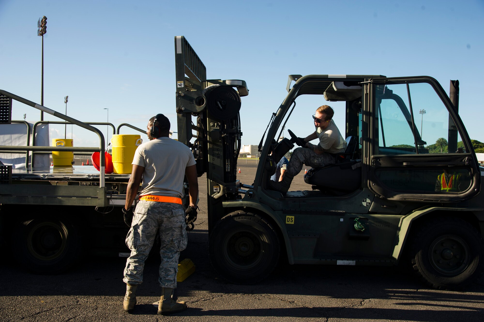Staff Sgt. Pernell Hart, 735th Air Mobility Squadron assistance shift supervisor, guides Senior Airman Ron Motz, air freight journeyman, through the second leg of the forklift obstacle during the Hickam Port Dawg Challenge, at Joint Base Pearl Harbor-Hickam, Hawaii, Nov. 17, 2017. The aerial port community hosts a Port Dawg Challenge every year to promote professionalism, and demonstrate air and space expeditionary force capabilities. (U.S. Air Force photo by Tech. Sgt. Heather Redman)