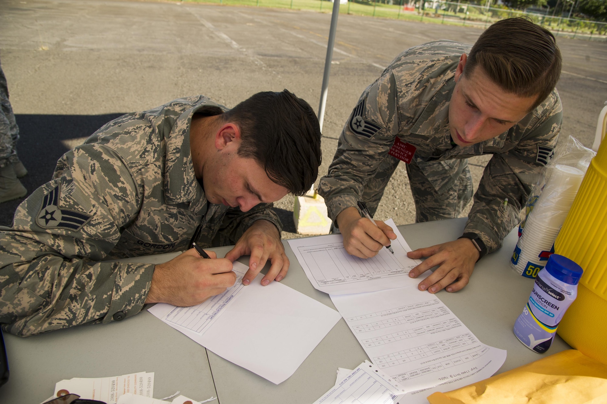 Senior Airman Chad Gordon and Staff Sgt. Robert Goody, 735th Air Mobility Squadron passenger terminal agents, fill out passenger manifests for the passenger and equipment loading competition during the Hickam Port Dawg Challenge, at Joint Base Pearl Harbor-Hickam, Hawaii, Nov. 17, 2017. The aerial port community hosts a Port Dawg Challenge every year to promote professionalism, and demonstrate air and space expeditionary force capabilities. (U.S. Air Force photo by Tech. Sgt. Heather Redman)