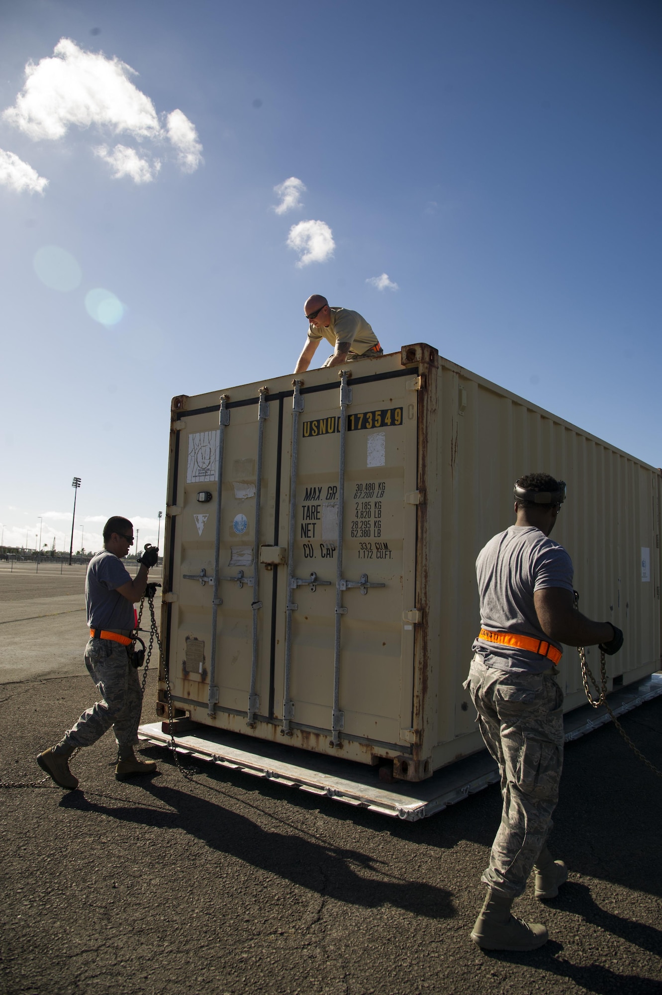 Tech. Sgt. Daniel Arrez, Staff Sgt. Nicholas Worrell, and Staff Sgt. Byron Patrick, from the 735th Air Mobility Squadron, secure a shipping container for the pallet build-up competition during the Hickam Port Dawg Challenge, at Joint Base Pearl Harbor-Hickam, Hawaii, Nov. 17, 2017. The aerial port community hosts a Port Dawg Challenge every year to promote professionalism, and demonstrate air and space expeditionary force capabilities. (U.S. Air Force photo by Tech. Sgt. Heather Redman)