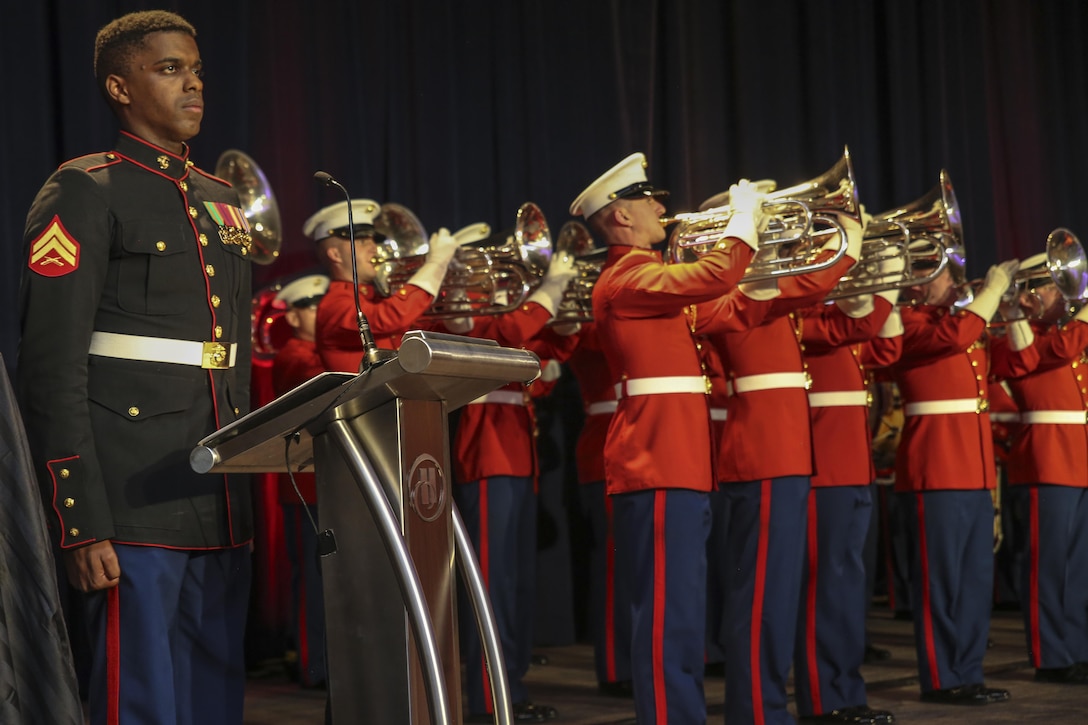 Corporal Andre Bastian, narrator, “The Commandant’s Own” U.S. Marine Drum & Bugle Corps, stands at the position of attention as the National and Marine Corps Colors are presented during the traditional Marine Corps birthday ceremony at the Washington Hilton, Washington D.C., Nov. 18, 2017. By tradition, the first piece of cake is given to the guest of honor and the second piece is given to oldest Marine present, which then passes it off to the youngest Marine which symbolizes the passing of knowledge and tradition to the newer generation of Marines.