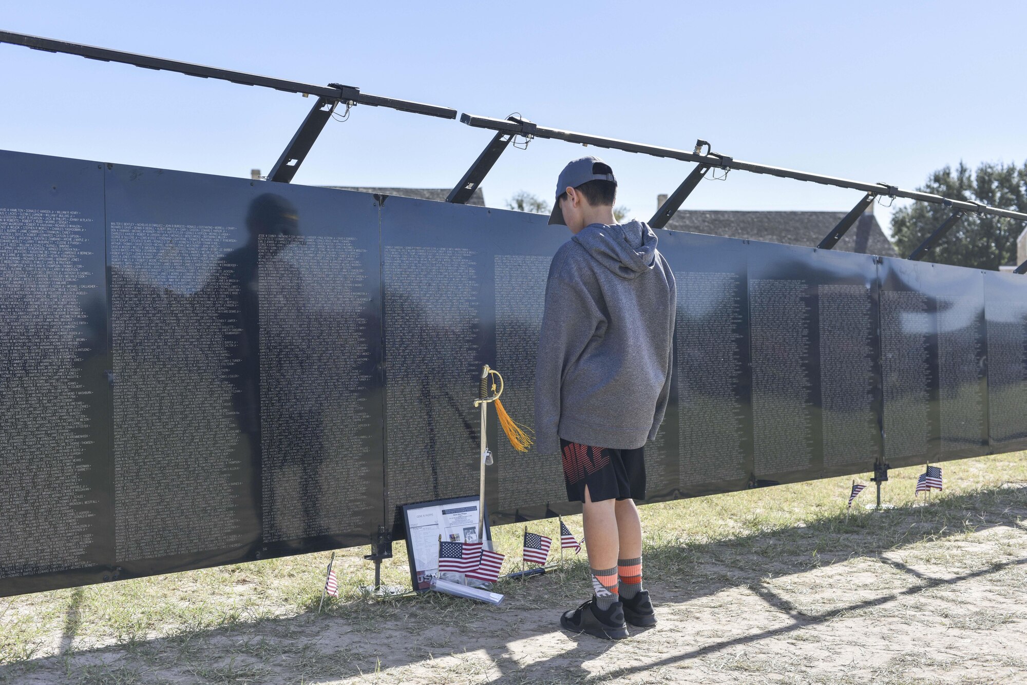 A child studies The Wall That Heals, a half-scale replica of the Vietnam War memorial, during the 50th Vietnam War Commemoration at the Fort Concho parade ground in San Angelo, Texas, Nov. 18, 2017.  The wall is approximately 250 feet in length, constructed of powder-coated aluminum, supported by an aluminum frame, and is made up of 24 individual panels. (U.S. photo by Airman 1st Class Randall Moose/released)