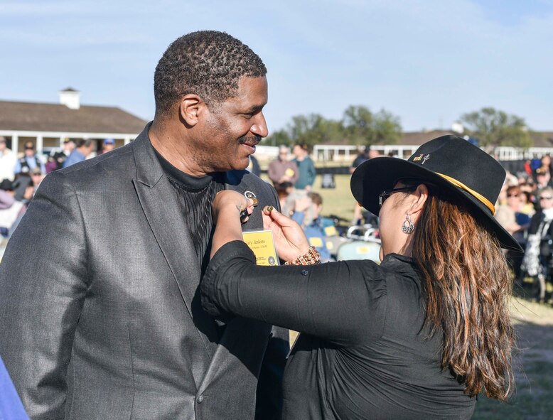 Gary Jenkins, 17th Training Wing Public Affairs audio visual production specialist, receives a Vietnam veteran lapel pin from Aryn Lockhart, 17TRW/PA visual information specialist, during the 50th Vietnam War Commemoration at the Fort Concho parade ground in San Angelo, Texas, Nov. 18, 2017.  The purpose of the pin is to recognize, thank and honor United States military veterans who served during the Vietnam War. (U.S. photo by Airman 1st Class Randall Moose/released)