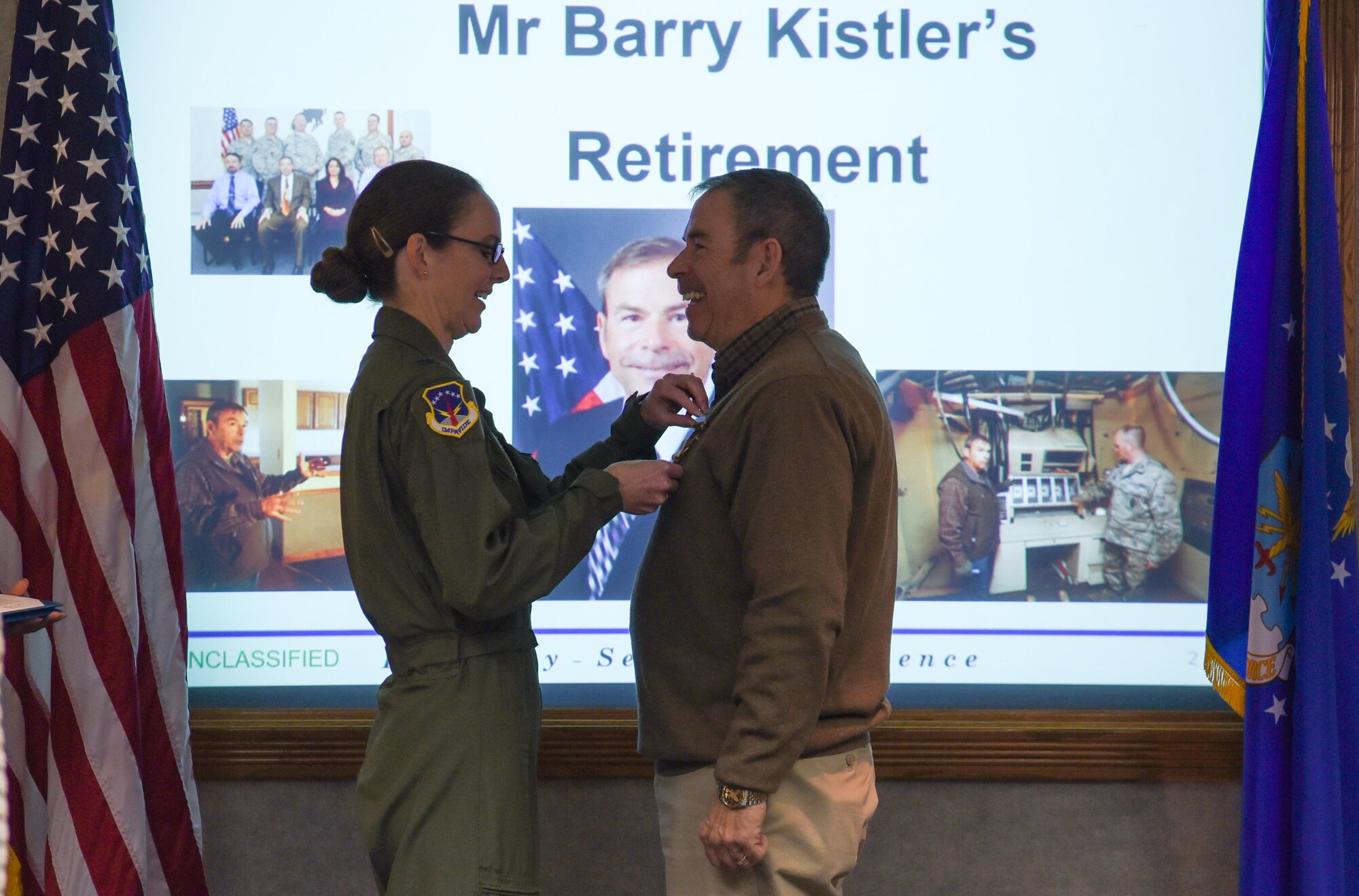 Col. Stacy Huser, 90th Missile Wing commander, clips the outstanding civilian career service medal to Berry Kistler, 90th Inspector General, November 8, 2017, on F.E. Warren Air Force Base, Wyo. Kistler served 30 years as active duty Air Force and 10 years as a civilian. (U.S. Air Force photo by Airman 1st Class Braydon Williams)