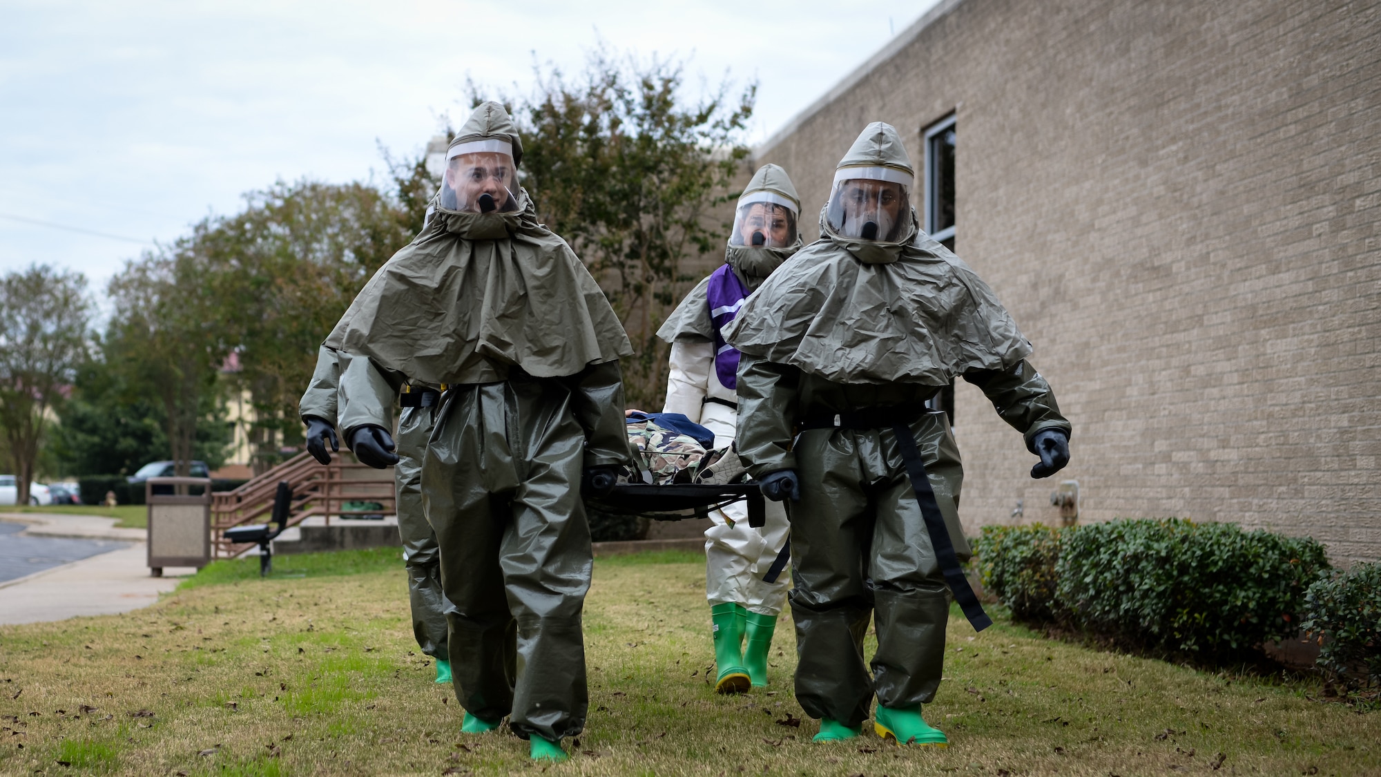 Decontamination team members from the 2d Medical Group carry a simulated chemical attack victim on a litter during a decontamination exercise on Barksdale Air Force Base, La., Nov. 15, 2017. Home station medical response includes decontamination, triage and a security team which uses the PAPR, a power air purified respirator suit which provides protection against CBRN agents. (U.S. Air Force photo by Staff Sgt. Benjamin Raughton)