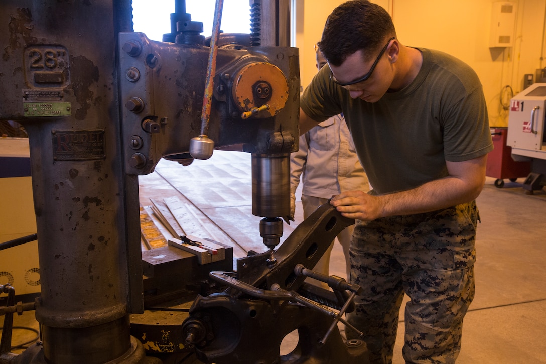 Cpl. Devin Perrell, a repair shop machinist and native of Bear Creek, N.C., removes a bolt stuck in a Humvee's pitman arm by drilling a hole through it and using an extractor to pull it out, Nov. 21, 2017, at Camp Kinser, Okinawa, Japan. The pitman arm is the piece of a vehicle that holds the wheel hub to the vehicle itself. The vehicle hardware was given to General Support Maintenance Company (GSM), 3rd Maintenance Battalion, 3rd Marine Logistics Group for repairs.