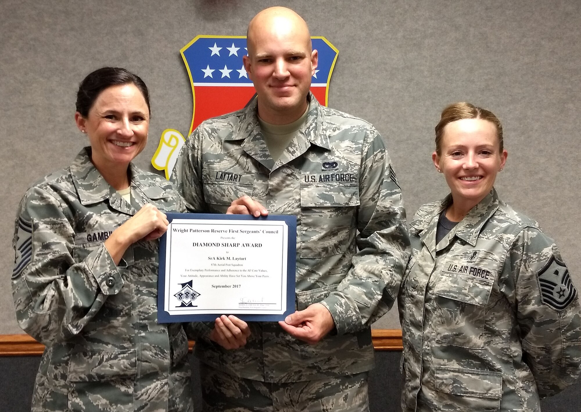 Senior Master Sgt. Rhonda Gambill, 87th Aerial Port Squadron first sergeant and Master Sgt. Sierra Cabungcal, 445th Operations Support Squadron first sergeant, present the September Diamond Sharp Award to Senior Airman Kirk Laytart, 87th APS, November 5th, 2017.