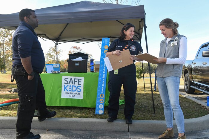 Malcolm DeFliece, Charleston County Emergency Medical Services paramedic crew chief, left, and Laura Kelley, North Charleston Fire Department fire and life safety educator, center, listen to Joyce Myrick, Safe Kids Charleston Area technician, right, go over one of the car seat assessments at the Hunt Community Center parking lot on Joint Base Charleston, Nov. 20, 2017.
