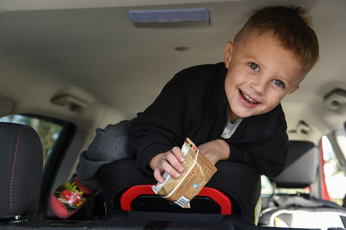 Grayson Rosengarten, three years old, climbs onto a car seat during the Safe Kids Charleston Area car seat assessment at the Hunt Community Center parking lot on Joint Base Charleston, S.C., Nov. 20, 2017.