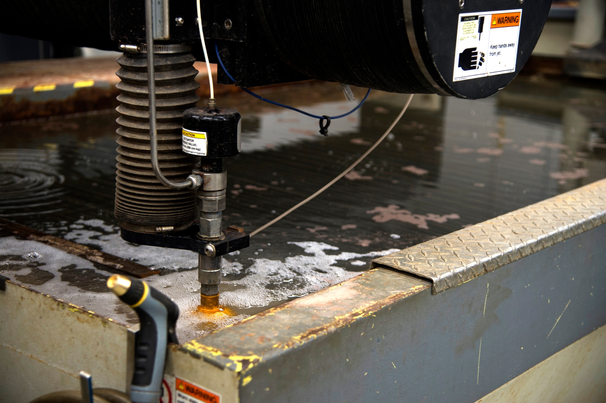 A water jet begins cutting a design into a piece of sheet metal at MacDill Air Force Base Fla., Nov. 7, 2017.