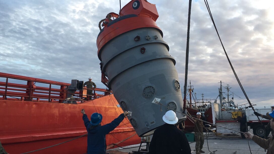 Sailors load submarine rescue equipment onto the Norwegian construction support vessel Skandi Patagonia