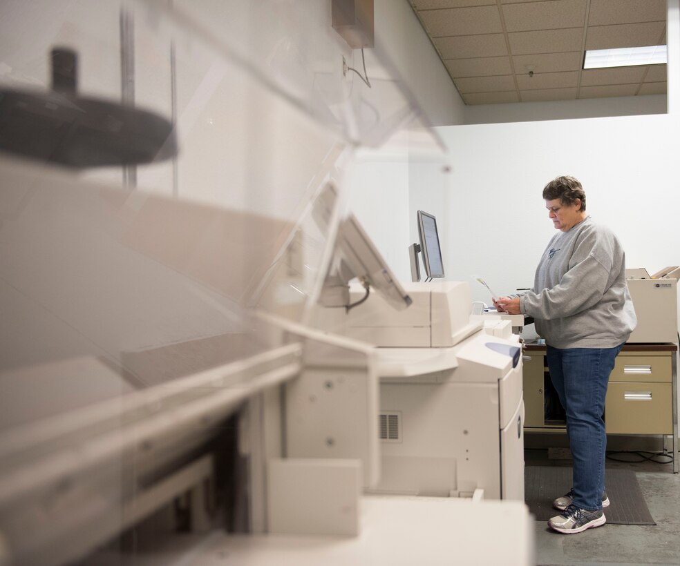 Photo of Teresa Blake, Documentation Automation Printing Services electronic duplicating system operator, inspecting a print job at Mountain Home Air Force Base, Idaho, Nov. 16, 2017.