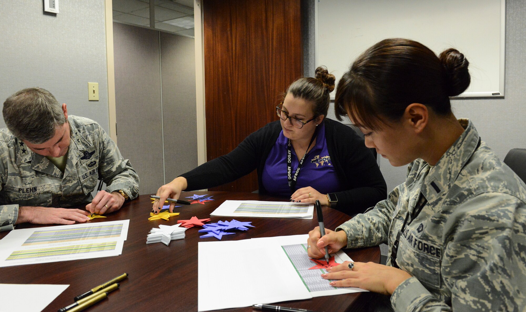 Maj. Gen. Michael Plehn, Air Force Special Operations Command deputy commander, Kalie Walters-Storer, AFSOC’s Preservation of the Force and Family community program peer network coordinator, and 1st Lt. Joanne Choi, A1 resilience and prevention branch chief, write names of the fallen on stars