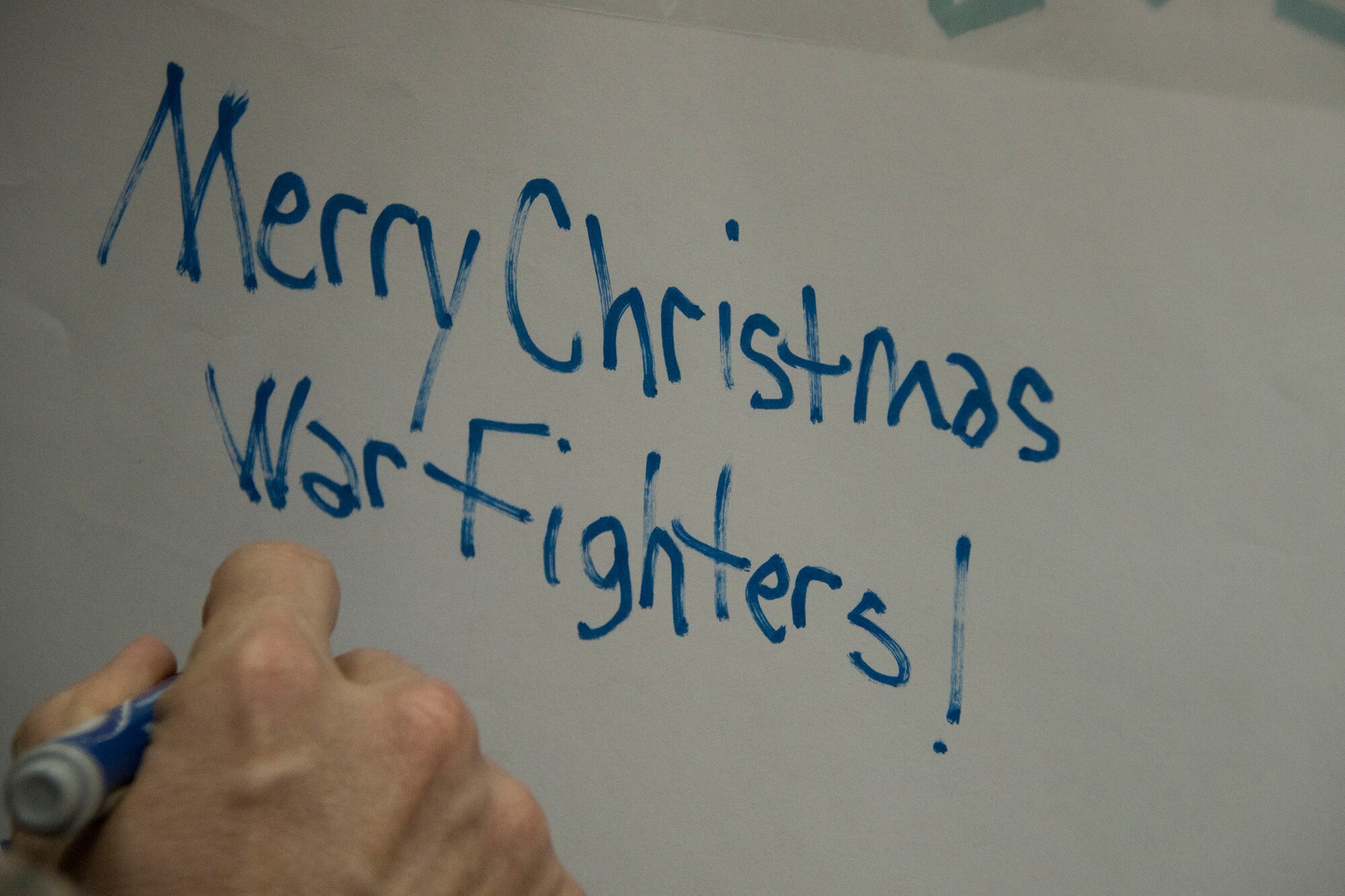 Chief Master Sgt. James Lucas, 386th Expeditionary Mission Support Group superintendent, writes a holiday greeting on the top of a box containing holiday meals for forward-deployed service members Dec. 23, 2016 at an undisclosed location in Southwest Asia. After the boxes were loaded with holiday meal items, they were loaded into the back of a C-130H Hercules and delivered to the austere locations where these service members are currently deployed. (U.S. Air Force photo/Staff Sgt. Andrew Park)