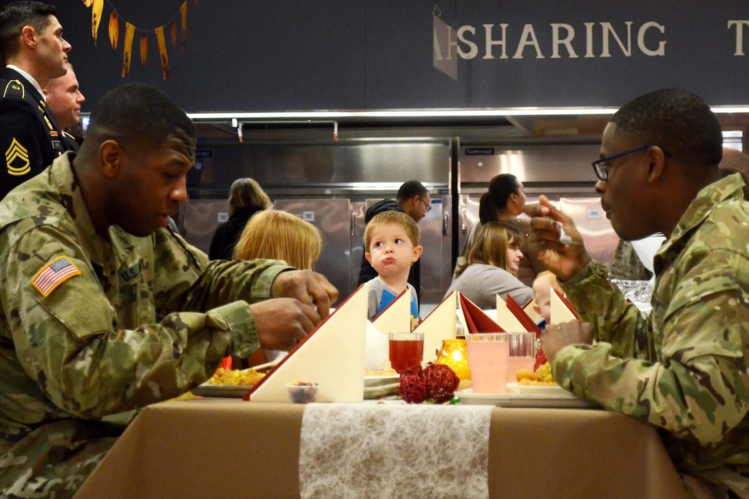 Soldiers and family members enjoy Thanksgiving dinner.