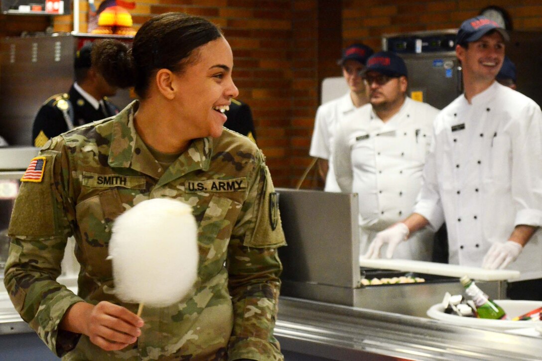 A soldier eats cotton candy.