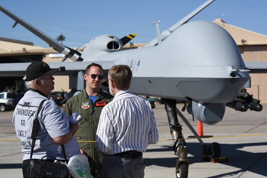 An Airman assigned to the 432nd Wing/432nd Air Expeditionary Wing speaks on the MQ-1 Predator and the MQ-9 Reaper displayed at the 2017 Aviation Nation Air and space Expo, Nov. 11, 2017, at Nellis Air Force Base, Nev. The event showcased some of the Air Force's premier aircraft and personnel dedicated to air superiority.