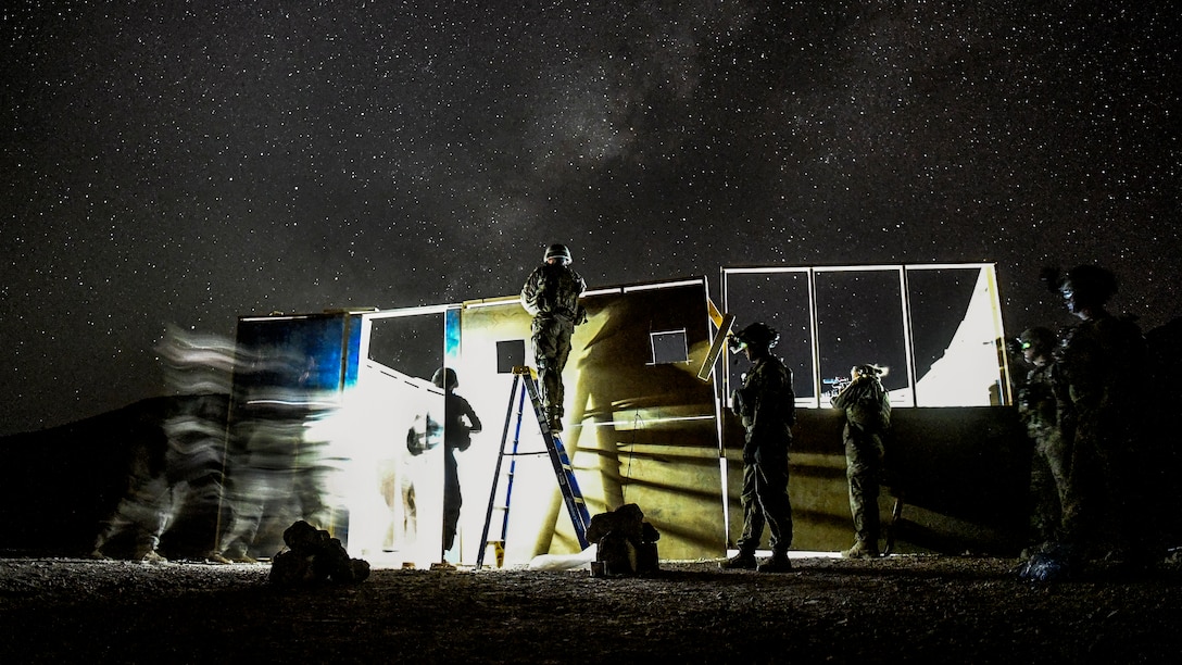 Soldiers train at night, conducting a live-fire shoot in a house.
