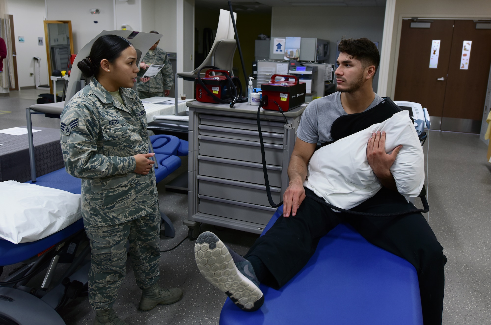 U.S. Air Force Senior Airman Tiffani-Amber Petit, left, a physical therapy technician assigned to the 509th Medical Operations Squadron, discusses post-shoulder surgery treatment with Senior Airman Moses Debraska, a security response member assigned to the 509th Security Forces Squadron, at Whiteman Air Force Base, Mo., Nov. 15, 2017.